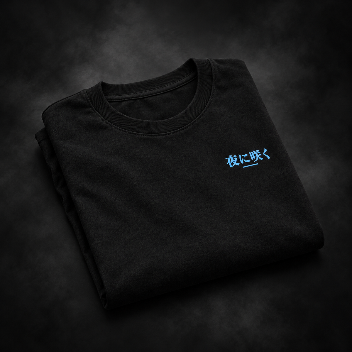 Folded black Yonakasaku T-shirt with icy blue Japanese chest logo